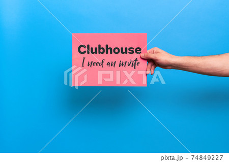 VICHUGA, RUSSIA - FEBRUARY 20, 2021: man's hand holds a banner with a call to invite him to social networking and communication app Clubhouse 74849227