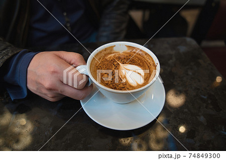 カフェで男性がコーヒーを飲むシーン 74849300