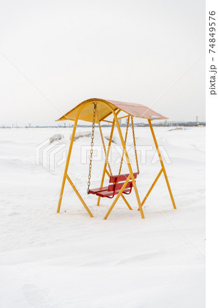 An old swing against the background of a snowy shore. An old swing against the background of a snowy shore. 74849576