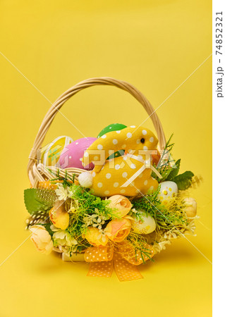 Colorful easter basket on a white wooden background Colorful easter basket on a white wooden background 74852321