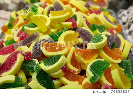 Fruit jelly in form of pieces of citrus fruits in an oriental sweets store. Fruit jelly in form of pieces of citrus fruits in an oriental sweets store. 74852837