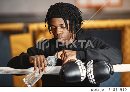 African male boxer in black gloves at the gym 74854910