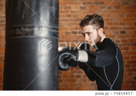 Male boxer in black gloves at the gym Male boxer in black gloves at the gym 74854957