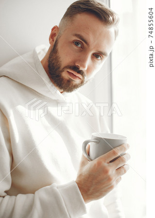 Attractive smart man standing in the living room Attractive smart man standing in the living room 74855604