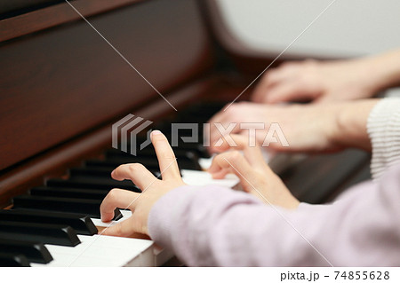 アップライトピアノを弾く5歳の女の子とママ 74855628