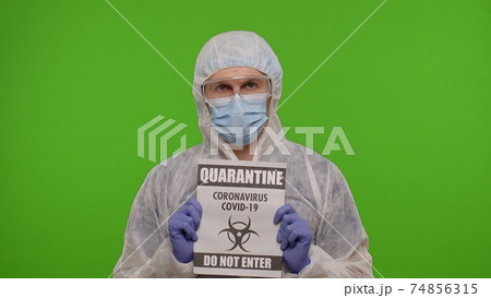 Doctor in suit showing warning text slogan on paper - Quarantine Covid-19 Coronavirus Do Not Enter 74856315