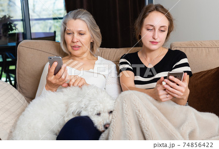 Women using phone at home 74856422