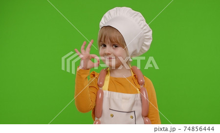 Child girl dressed in apron like chef cook showing approval ok sign, tasty gesture, chroma key Child girl dressed in apron like chef cook showing approval ok sign, tasty gesture, chroma key 74856444
