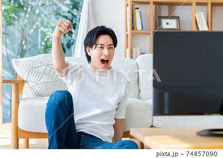 リビングでテレビを見る若い男性 74857090