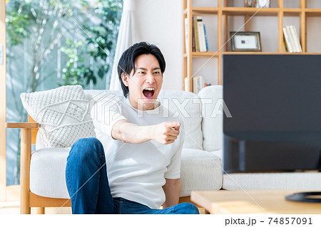 リビングでテレビを見る若い男性 74857091