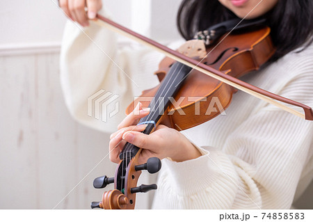 弦が1本切れたバイオリンを弾く女の子の写真素材