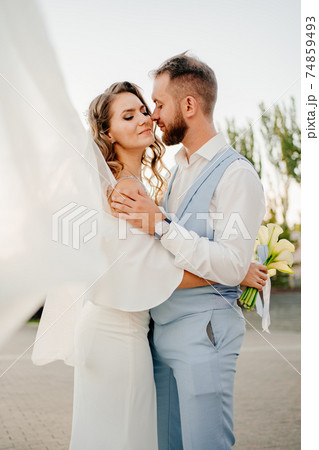 solar glare. bride with long curls in a white elegant dress with a calla lilies. 74859493