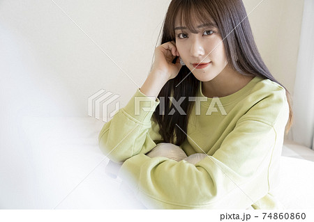 ベッドに座る綺麗な女性のポートレートの写真素材