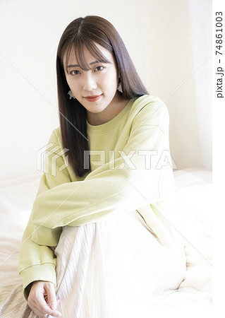 ベッドに座る綺麗な女性のポートレート 74861003