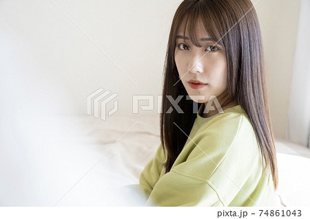 ベッドに座る綺麗な女性のポートレートの写真素材