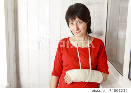 a broken arm. Close-up of the plaster. A lady in a red jacket with a bright manicure. exercises to restore and strengthen the muscles. damage to the bones. a broken arm. Close-up of the plaster. A lady in a red jacket with a bright manicure. exercises to restore and strengthen the muscles. damage to the bones. 74861232