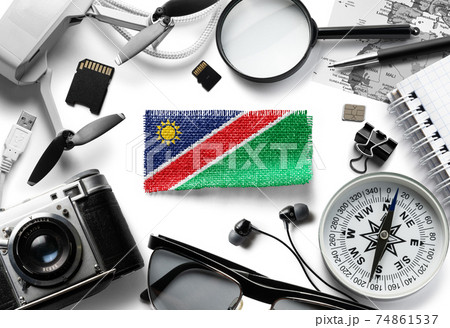 Flag of Namibia and travel accessories on a white background. 74861537
