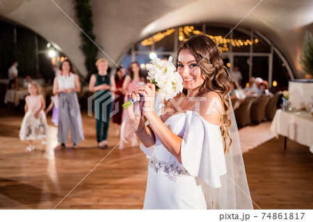 wedding tradition to throw a bouquet of bridesmaids. Fun. bride with long curls. 74861817