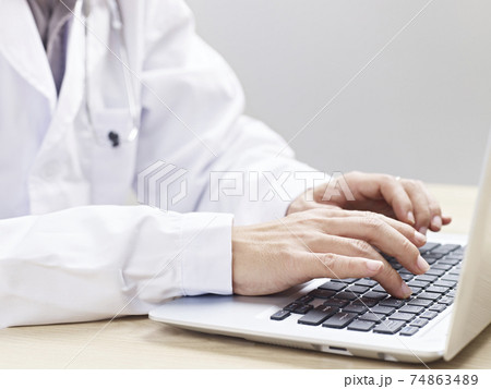 hands of a doctor typing on laptop computer 74863489