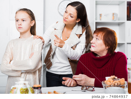 Offended little while mom and granny scolding her Offended little while mom and granny scolding her 74864937