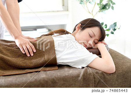 ベッドでマッサージ（整体）を受ける若い女性 74865443