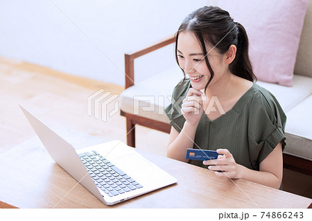 自宅でネットショッピングを楽しむ若い女性 自宅でネットショッピングを楽しむ若い女性 74866243