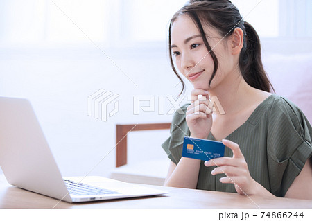 自宅でネットショッピングを楽しむ若い女性 自宅でネットショッピングを楽しむ若い女性 74866244