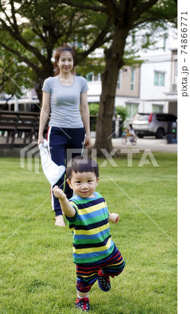 Mother and child are playing in the playground.  74866771