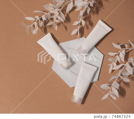 White tubes of cream on a brown background 74867324