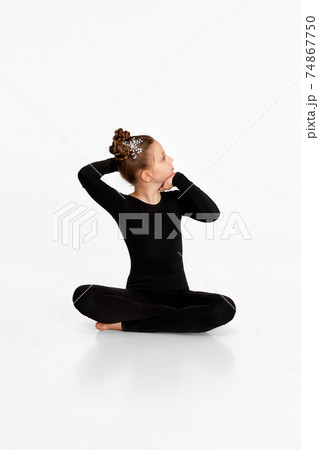 child girl in black sportswear doing stretching. 74867750