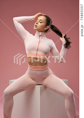 Attractive young woman in fitness suit posing in studio 74869307