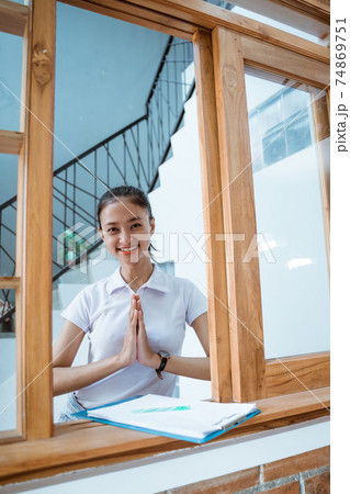 attractive homestay owner welcoming guest at her hotel 74869751