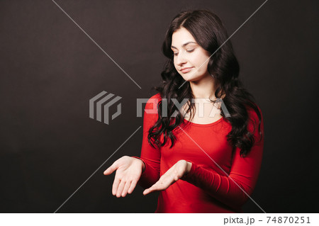 Doubtful confused woman with cupped hands 74870251