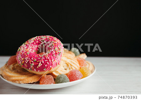 Plate with unhealthy sugary sweets, copy space 74870393