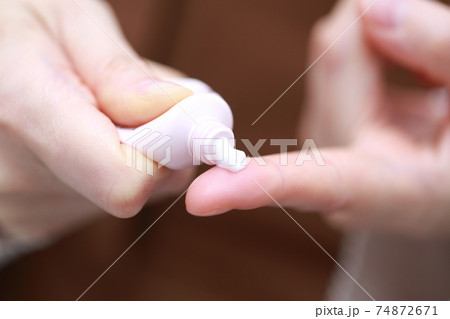 塗り薬を押し出す女性の指 塗り薬を押し出す女性の指 74872671