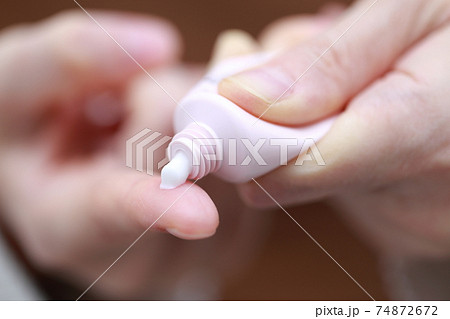 塗り薬を押し出す女性の指 74872672