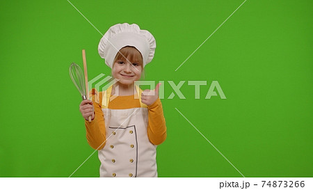 Child girl kid cook chef baker posing, smiling, showing thumb up on green chroma key background Child girl kid cook chef baker posing, smiling, showing thumb up on green chroma key background 74873266