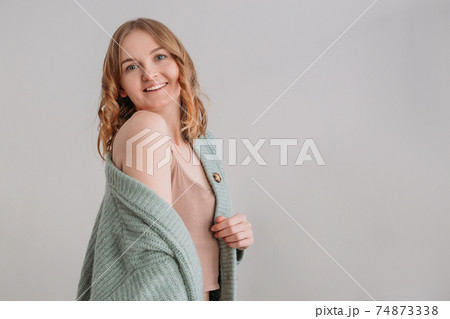 Image of happy young woman posing isolated over grey wall background. Beautiful female looks at camera having her blonde hair. Face expression, feelings and attitude Image of happy young woman posing isolated over grey wall background. Beautiful female looks at camera having her blonde hair. Face expression, feelings and attitude 74873338