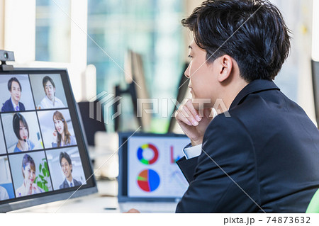 テレワーク中の仲間とオンライン会議をするビジネスマン 74873632