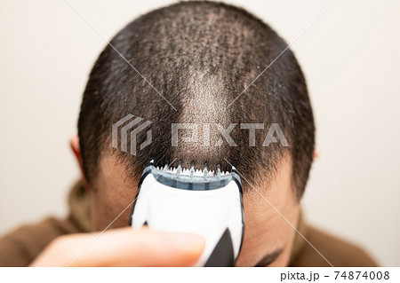 バリカンで髪を切る男性 74874008