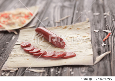 preparation of Shawarma.spicy sausages, pita bread and cabbage salad on a wooden table preparation of Shawarma.spicy sausages, pita bread and cabbage salad on a wooden table 74874795