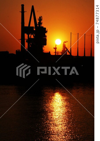 輸入船と工場の向こうに沈む夕日 74877314