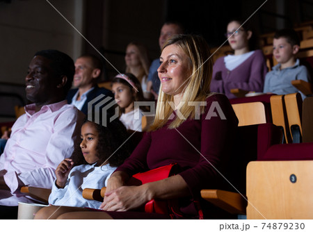 European woman with preteen mulatto girl and aframerican man in cinema 74879230