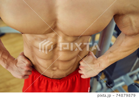 Close-up of muscle on belly of a bodybuilder in the gym 74879879