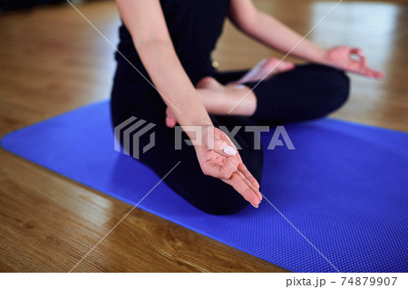Girl sitting in a yoga pose gym. Relaxation, meditation, health 74879907