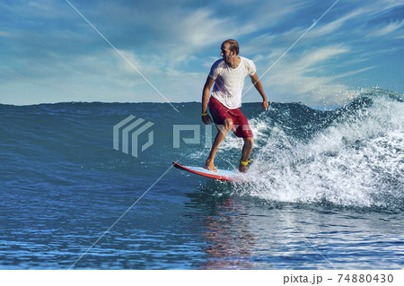 Male surfer on a blue wave 74880430