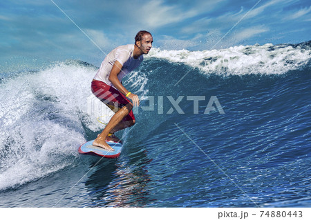 Male surfer on a blue wave 74880443