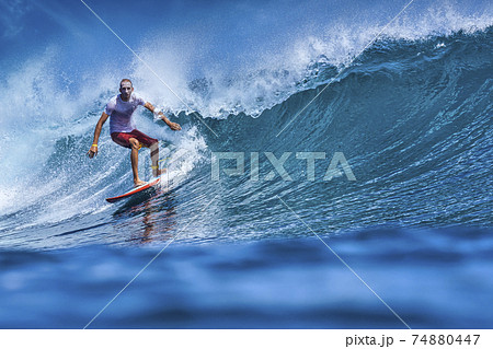 Male surfer on a blue wave Male surfer on a blue wave 74880447