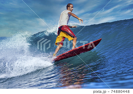 Male surfer on a blue wave 74880448
