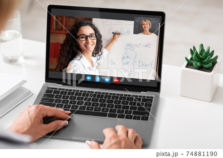 Unrecognizable woman sitting at desk using laptop, having video call 74881190